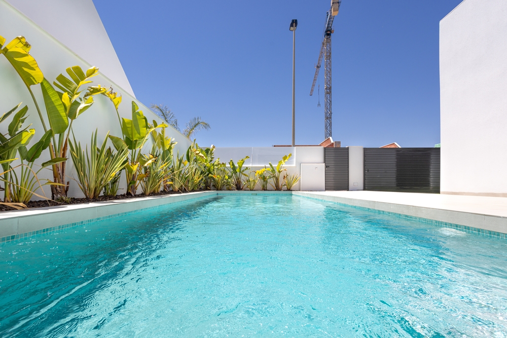 Long,Private,Pool,Surrounded,By,Tropical,Plants,And,White,Walls,