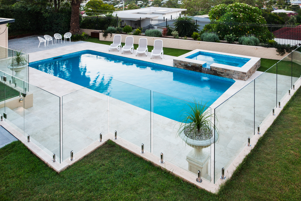 Modern,Swimming,Pool,Covered,With,Glass,Panels,Beside,A,Green